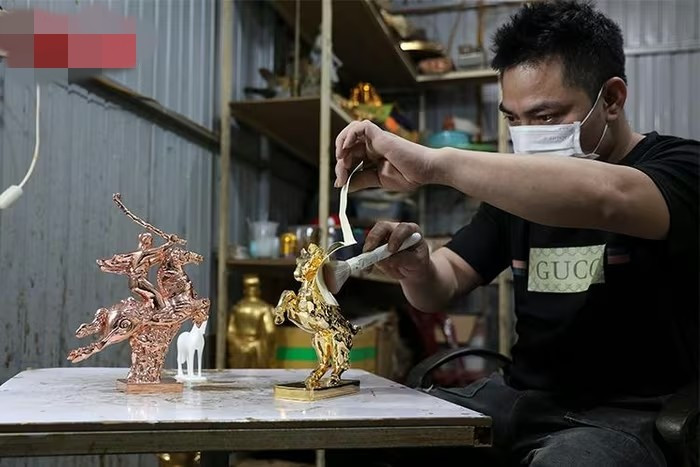 Công đoạn phủ và hoàn thiện bề mặt linh vật được thực hiện hoàn toàn thủ công. Ảnh: Baotintuc