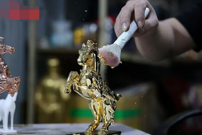 Từng lớp vàng mỏng được phủ tỉ mỉ, giúp bề mặt linh vật đạt độ phản quang đồng đều và sắc nét. Ảnh: Baotintuc
