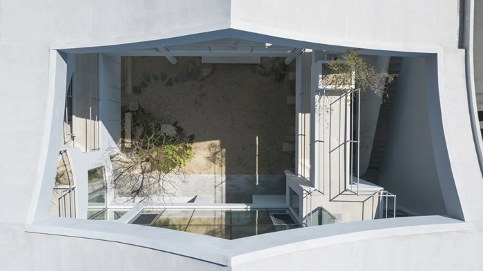 Nhìn từ trên xuống, sân trong được bao bọc bởi lớp mái cong, mang đến cảm giác một không gian tách biệt. Ảnh: Architizer