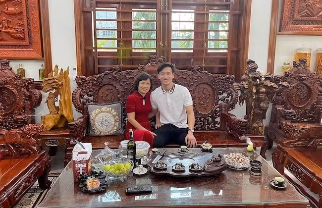 Phòng khách rộng, nổi bật với bộ bàn ghế gỗ lớn, thiết kế cầu kỳ. Ảnh: FBNV