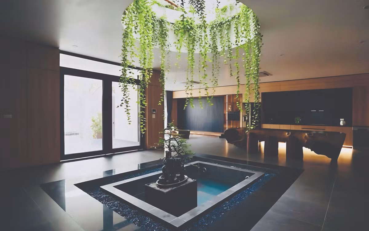 Tầng trệt bố trí xoay quanh hồ cá trung tâm, yếu tố điều hòa vi khí hậu của ngôi nhà. Ảnh: NguyenhieuARC
