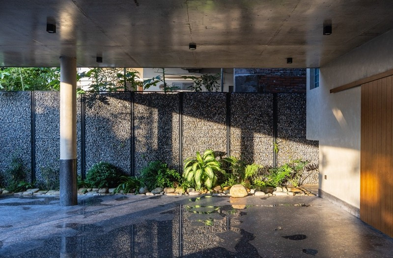 Bước qua cánh cổng là một không gian rộng mở, khoáng đãng, với khoảng sân đa chức năng, được bao bọc bởi hệ tường rọ đá kết hợp với những mảng xanh dịu và hồ nước trong veo. Ảnh: Trieu Chien