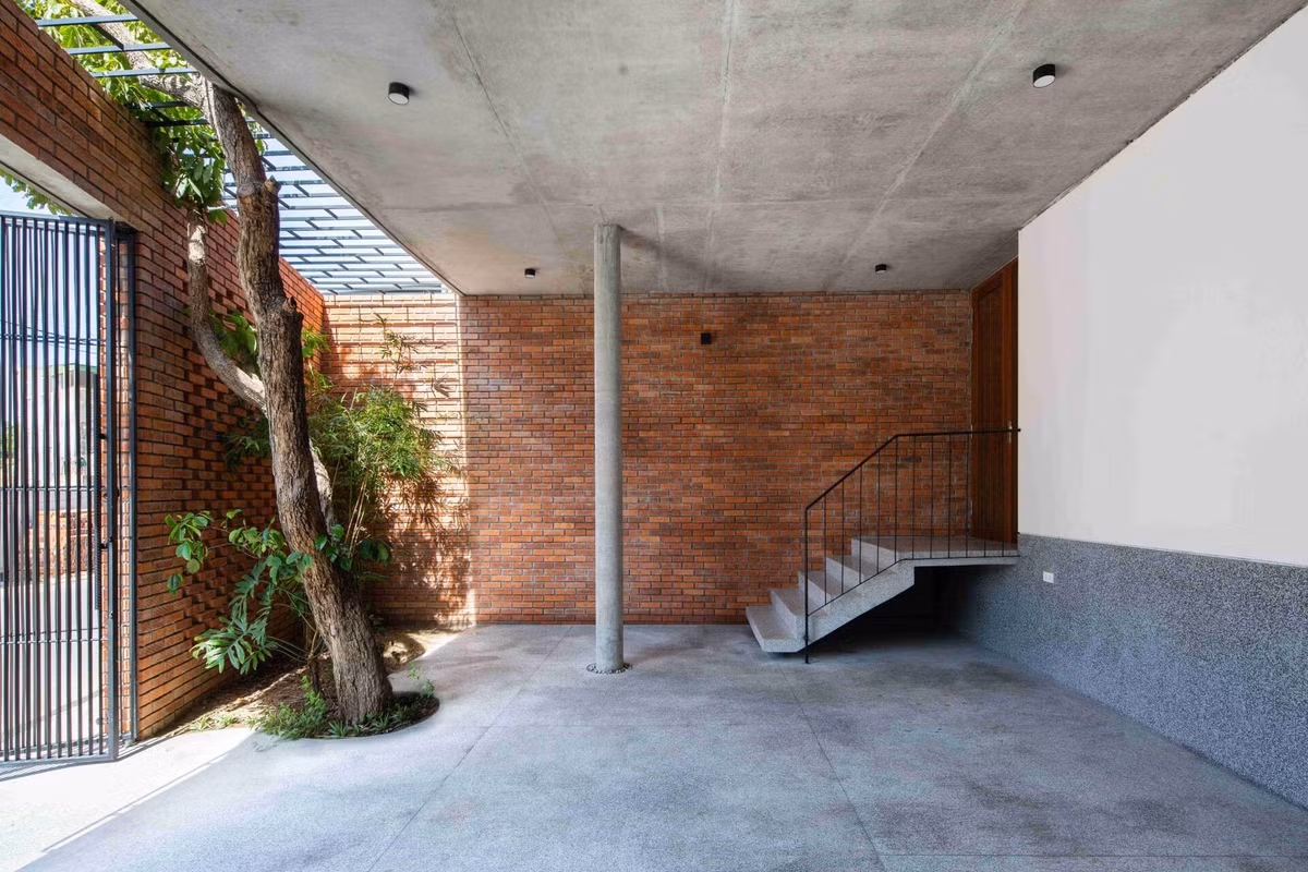 Để khắc phục tình trạng ngập lụt, kiến trúc sư nghiên cứu và thay đổi cao độ của ngôi nhà. Không gian gara, sân vườn phía trước được nâng lên vừa đủ để thuận tiện cho việc tiếp cận. Ảnh: Hoàng Lê