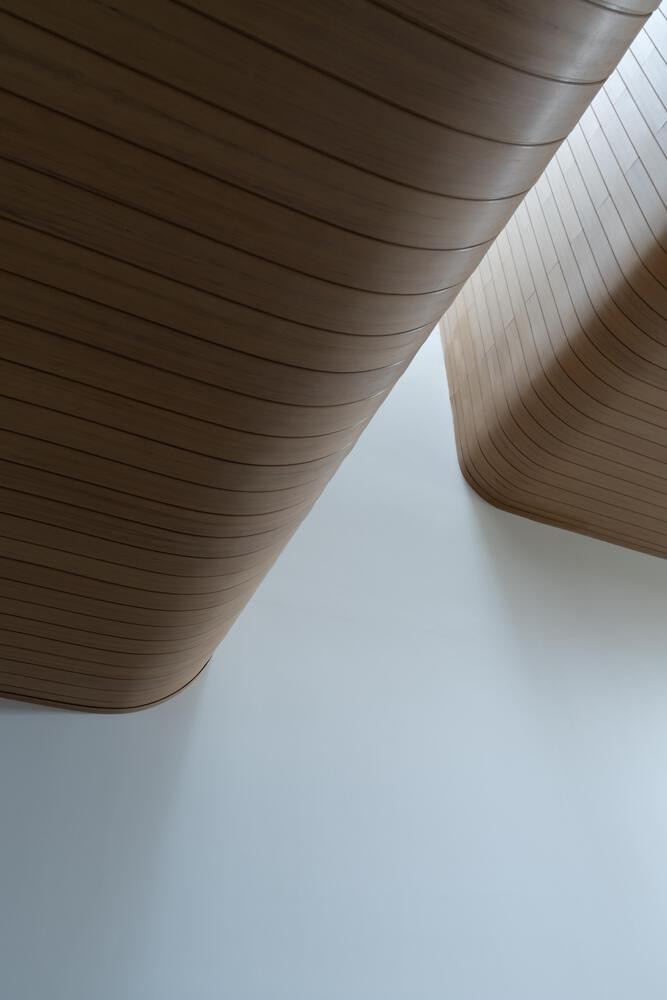 Điểm nhấn đặc biệt của dự án là trần nhà bằng gỗ nhân tạo uốn cong, trải dài liên tục từ không gian nội thất ra ban công ngoài trời. Ảnh: Quang Trần