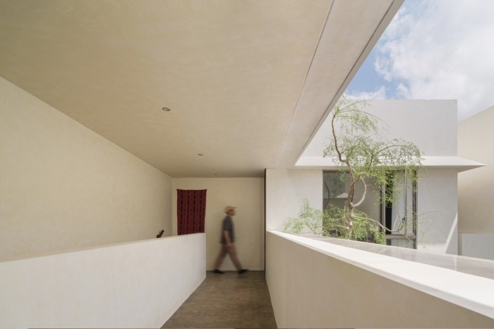 Hành lang tầng trên mở ra sân trong, lấy sáng tự nhiên và thông gió chéo. Ảnh: Archdaily