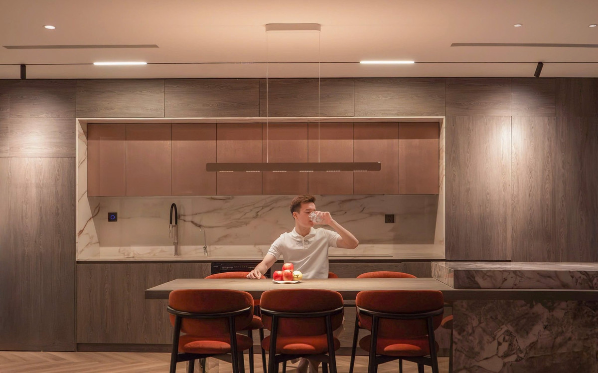 Đá vân chạy xuyên suốt từ bàn trà đến đảo bếp giúp tổng thể hài hòa và sang hơn mà không cần quá nhiều chi tiết trang trí. Ảnh: FB Hoàng Đức