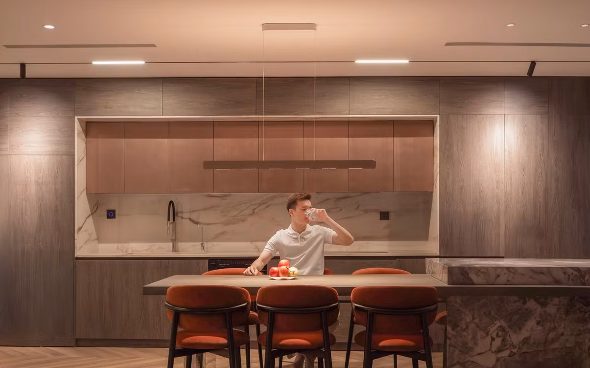 Đá vân chạy xuyên suốt từ bàn trà đến đảo bếp giúp tổng thể hài hòa và sang hơn mà không cần quá nhiều chi tiết trang trí. Ảnh: FB Hoàng Đức