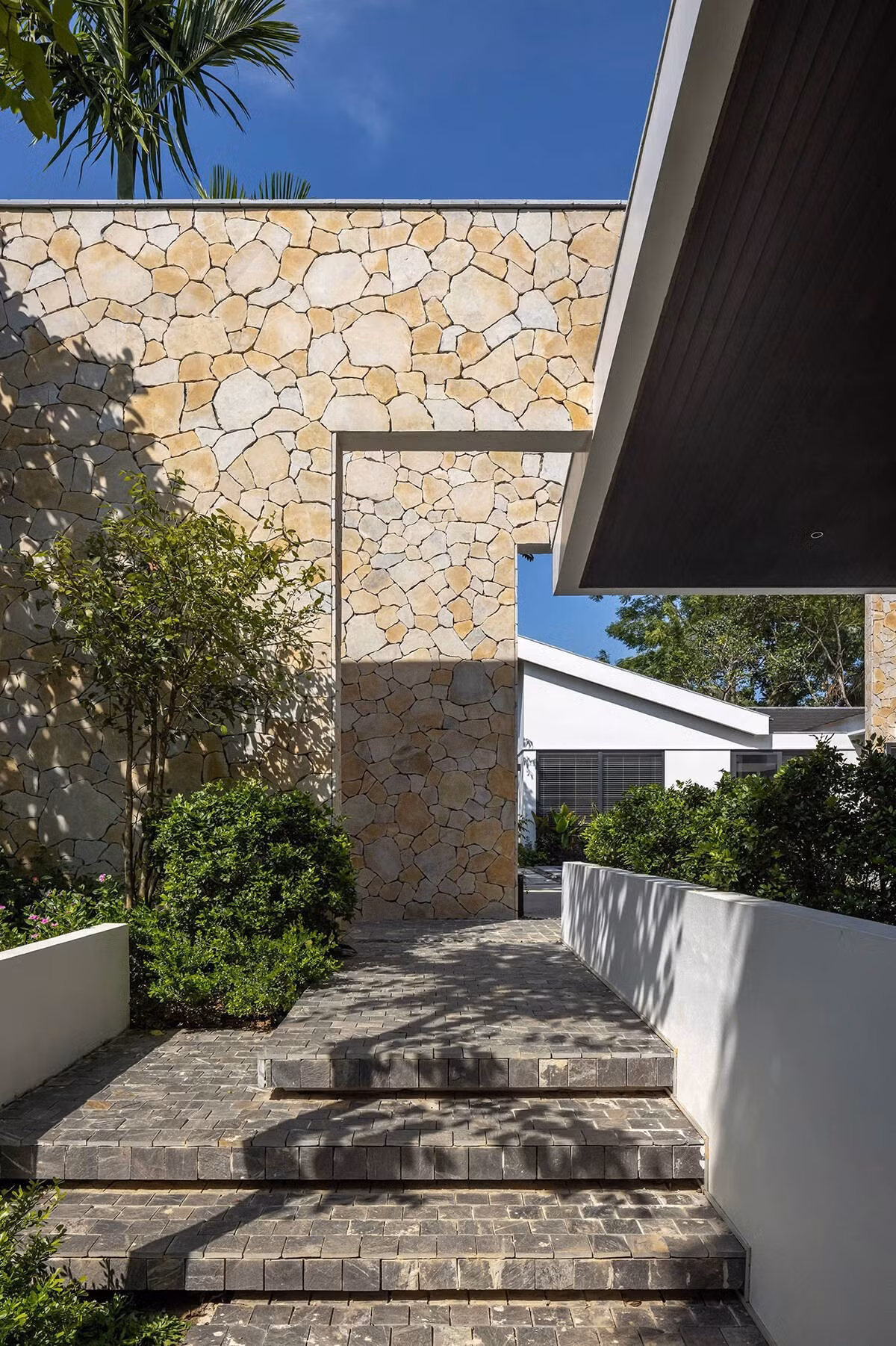 Vật liệu sử dụng là sự kết hợp hài hòa giữa vật liệu truyền thống địa phương và hiện đại: đá tự nhiên, gỗ, gạch nung đan xen cùng kính và nhôm. Ảnh: Chimnon Studio