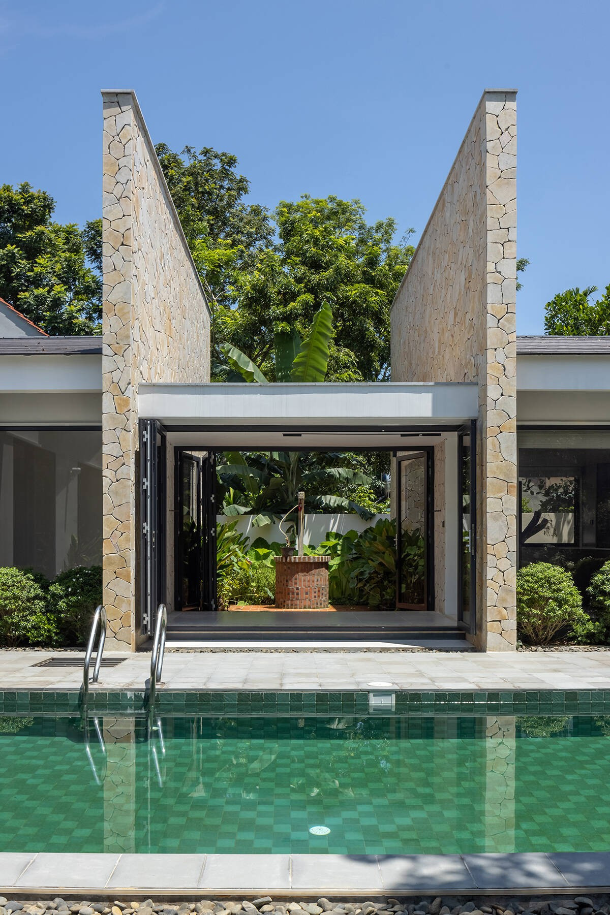 Giếng nước cũ được giữ lại, đặt ở trung tâm của sân trong, là "trục ký ức" xuyên suốt công trình. Ảnh: Chimnon Studio