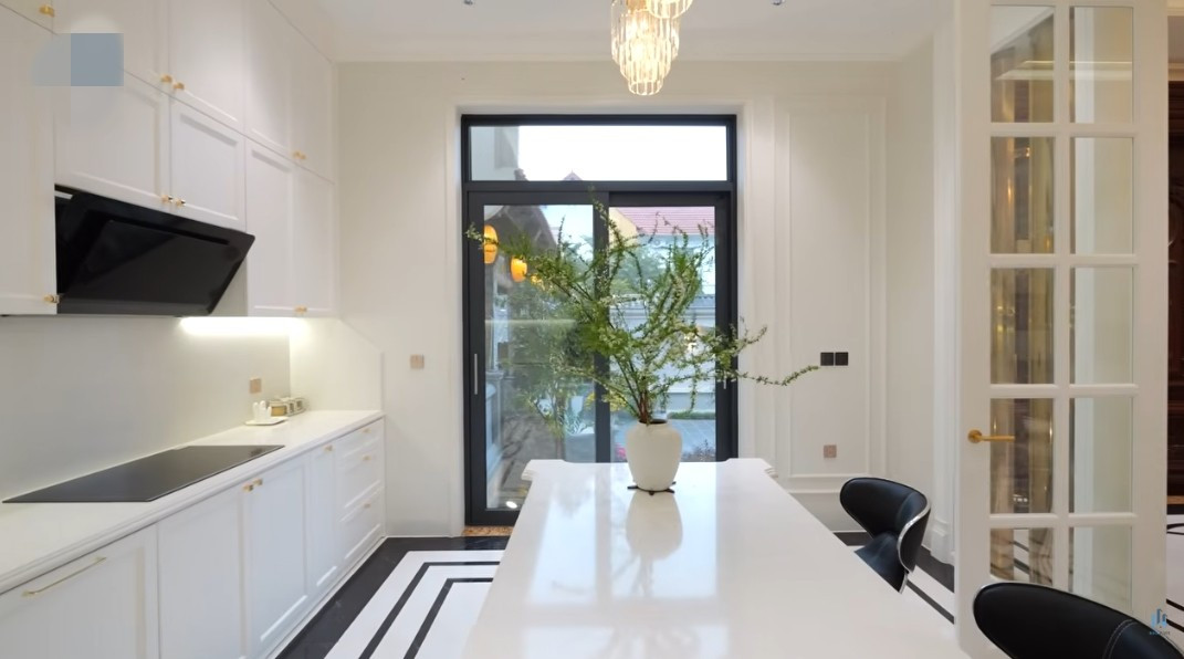 Khu bếp luôn thoáng đãng nhờ bố trí nhiều cửa kính lấy sáng. Ảnh chụp màn hình NhaF