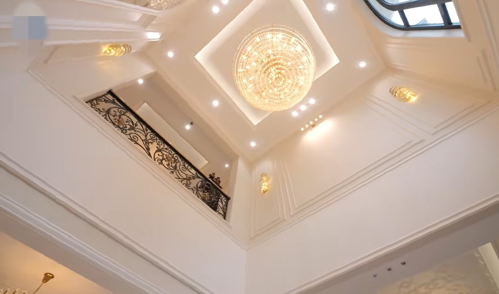 Sau cửa chính là khoảng thông tầng với chiếc đèn chùm lớn tạo điểm nhấn. Ảnh chụp màn hình NhaF