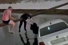 Người dân cứu một phụ nữ và một đứa trẻ khỏi chiếc taxi bị rơi xuống nước