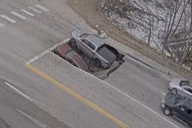 Hai chiếc xe hơi bị hố sụt nuốt chửng khi đang chờ đèn đỏ 