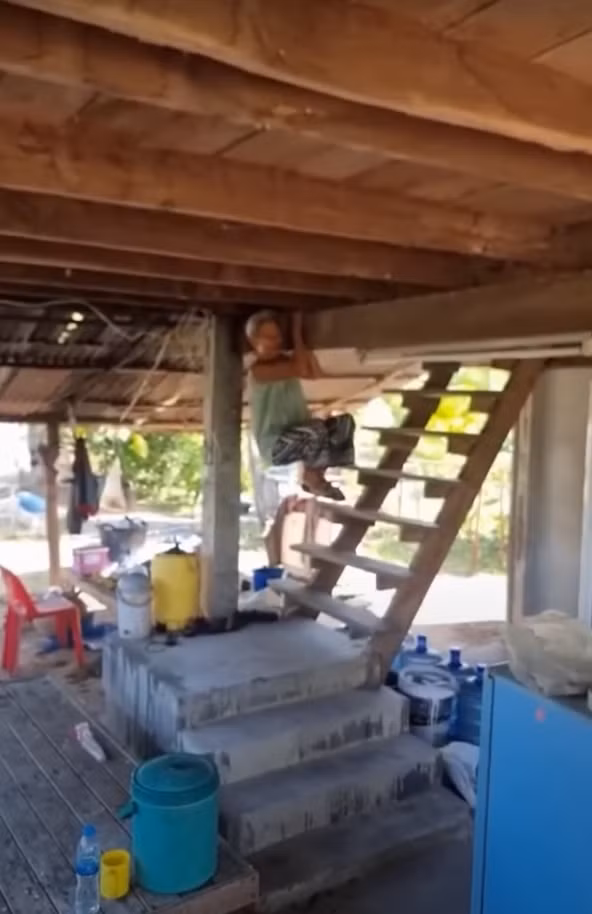 Từ một bà cụ 80 tuổi di chuyển khá chậm chạp, lúc này bà ấy như được truyền sức sống của tuổi trẻ, nhảy một cái phốc bám vào một thanh dầm trần nhà. Ảnh: @สํานักข่าวไทย TNAMCOT (MCOT).
