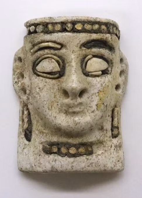 Chiếc mặt nạ mô tả khuôn mặt một phụ nữ với dải băng đô, vòng cổ và khuyên tai, mặt dây chuyền được khảm những mảnh vỏ sò. Đôi mắt to hình quả hạnh, đường viền mắt và lông mày cũng được khắc họa rõ nét. Ảnh: @Bảo tàng Iraq.