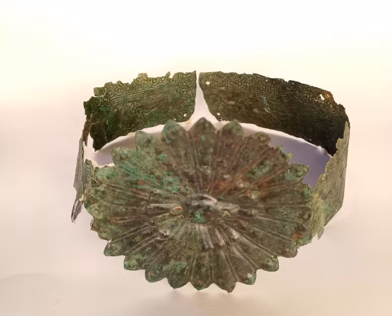 Bà được chôn cất với một vương miện bằng đồng có dải, trên đó có một hoa lớn hình mặt trời rực rỡ ở giữa trán. Ảnh: @Hội đồng Khảo cổ Phthiotis và Evrytania.