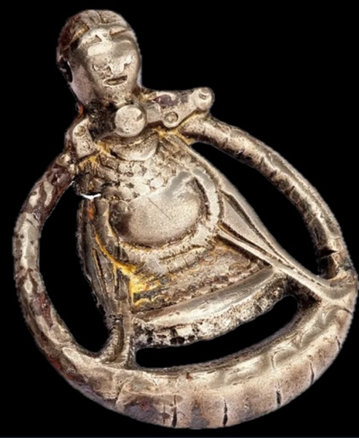 Tuy nhiên, điều gây sốc là trên mặt dây chuyền này khắc họa họa tiết một phụ nữ Viking đang mang thai. Cụ thể, một chiếc vòng bao quanh một phần hình người phụ nữ đứng với hai chân dang rộng và hai tay chắp lại dưới bụng bầu. Ảnh: @Bảo tàng Lịch sử Thụy Điển.