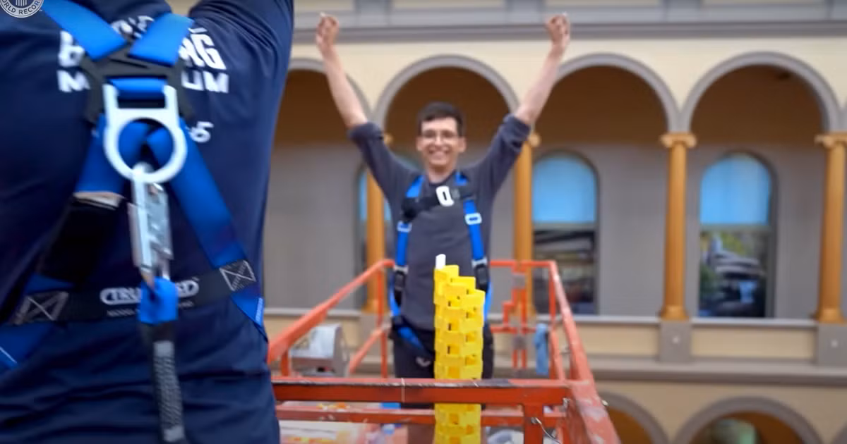 Khi quân domino cuối cùng được đặt lên trên cùng đỉnh khối domino, đám đông theo dõi tại Bảo tàng Xây dựng Quốc gia ở Washington, DC, Mỹ đã reo hò và vỗ tay, và các thành viên trong nhóm đã trèo xuống khỏi thang xe nâng để ôm nhau ăn mừng. Ảnh: @guinnessworldrecords.