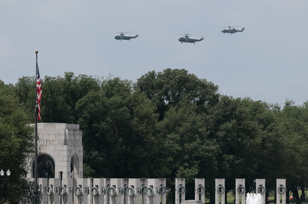 Hôm 9/6, đoàn máy bay hộ tống bay cùng trực thăng Marine One đang chở Tổng thống Mỹ Donald Trump bay qua Đài tưởng niệm Chiến tranh Thế giới thứ II, khi Nhà Trắng đang khẩn trương chuẩn bị cho lễ diễu binh. Ảnh: @Kayla Bartkowski/Getty.