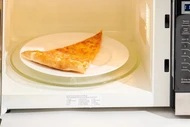 Vì sao đĩa lò vi sóng cứ xoay khi hâm nóng thức ăn?