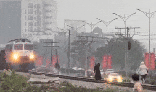 Hai người phụ nữ chụp hình trên đường ray, tàu hỏa phải phanh gấp