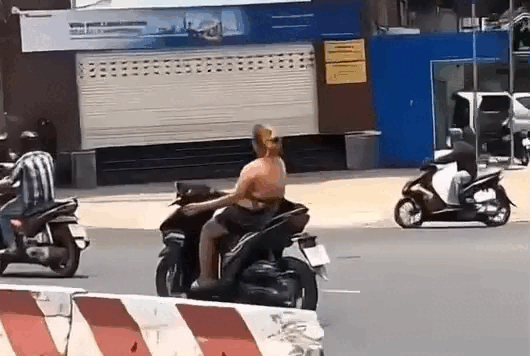 Cô gái buông hai tay, nhảy múa khi chạy xe máy ở TPHCM