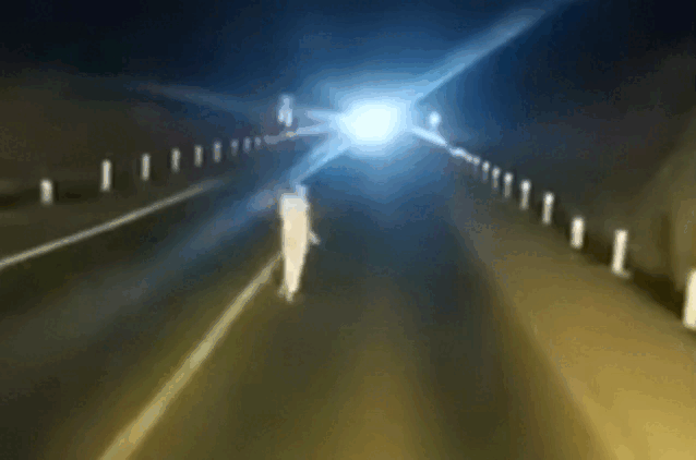 Cô gái xõa tóc, mặc đồ trắng đi trên cao tốc trong đêm tối