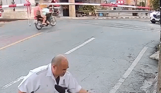 Chồng lái xe cố băng qua đường ray, vợ vướng rào chắn ngã nhào