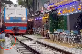 Ngồi sát đường ray, cô gái bị tàu hỏa hất văng điện thoại khỏi tay