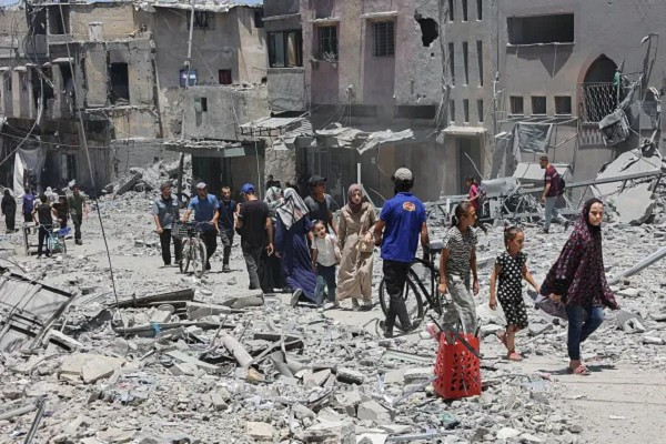 Người dân Palestine đi qua đống đổ nát của những tòa nhà bị phá hủy trong cuộc tấn công của Israel vào khu phố Daraj ở Thành phố Gaza. Ảnh: Getty. gaza.png