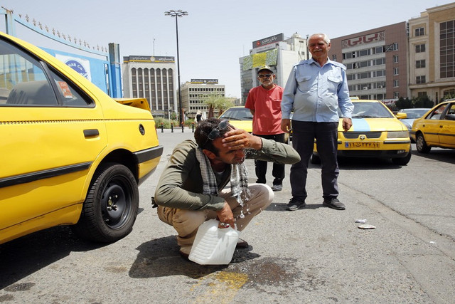 Một tài xế taxi cố gắng làm mát khi nhiệt độ tăng cao tại Tehran. Ảnh: EPA. iran.png