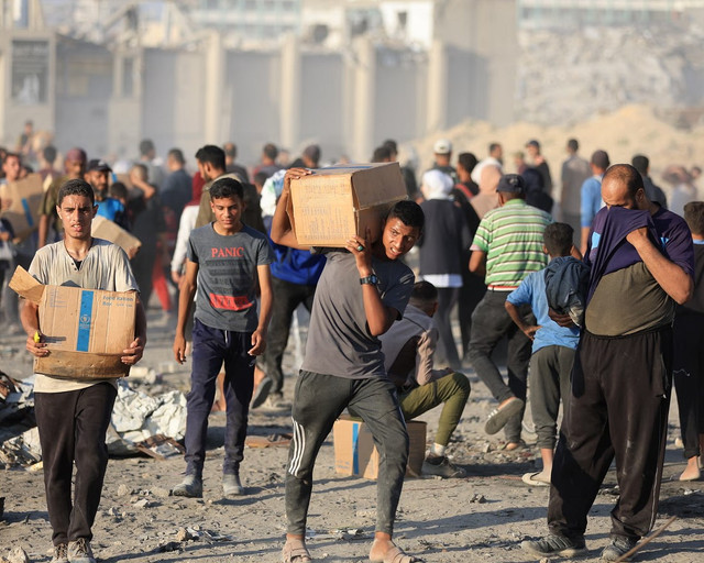 Người dân mang theo đồ viện trợ do GHF phân phát. Ảnh: Anadolu. gaza.png