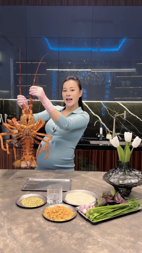 Phòng khách được thiết kế theo phòng cách hiện đại theo tone màu chủ đạo xám be tạo cảm giác sang trọng, thanh lịch. Phần tường xám treo đèn trang trí hình mặt trăng kích thước lớn đầy ấn tượng, có lẽ được gia chủ lấy cảm hứng từ giải ngân hà để decor khu vực này. Điểm nhấn của phòng khách là hệ đèn chùm xanh cao cấp vừa có tác dụng chiếu sáng, vừa thể hiện gu "chơi" nội thất đỉnh cao của đôi vợ chồng.