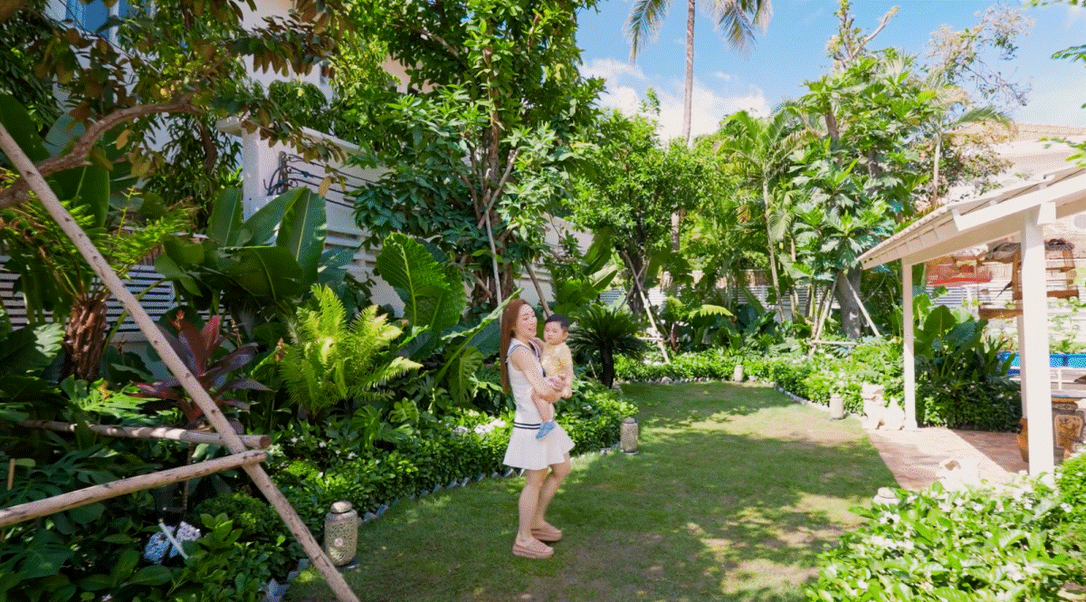 Khu vườn được thiết kế thành sân chơi với thảm cỏ, cây cảnh, mái hiên... Ảnh chụp màn hình