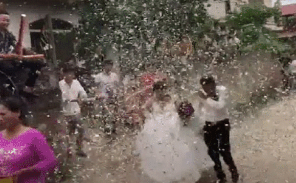 Vui thôi đừng vui quá, cặp cô dâu, chú rể này phải nhận trận mưa pháo giấy từ những người bạn.
