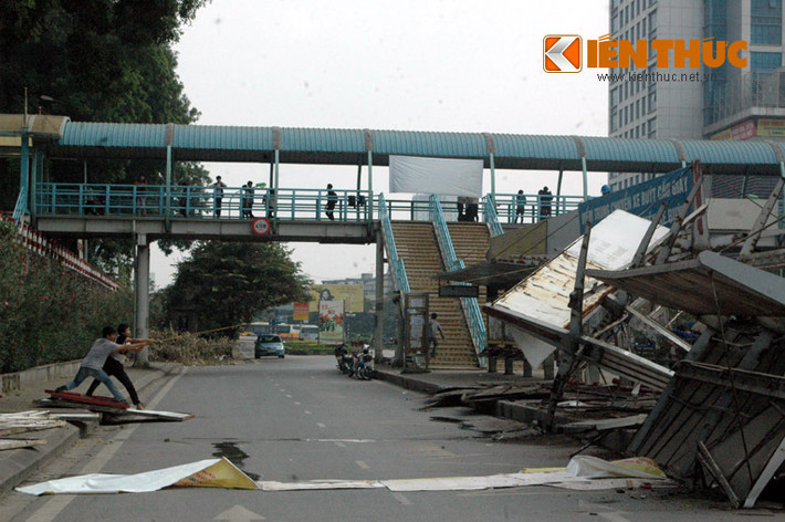 Các công nhân khẩn trương kéo đổ phần khung trạm trung chuyển xe buýt này để chuyển đi nơi khác.