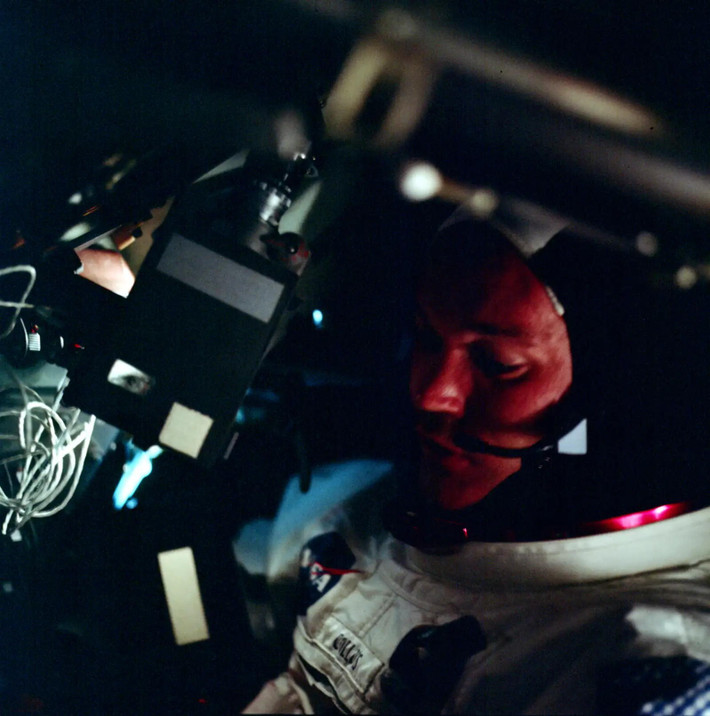 Michael Collins, một trong những phi hành gia của Apollo 11 cầm máy quay phim khi ở khoang chỉ huy tàu Apollo (Apollo Command Module). Là sứ mệnh lịch sử của nhân loại, NASA đã chuẩn bị nhiều thiết bị ghi hình để phát trực tiếp khoảnh khắc con người đặt chân lên Mặt Trăng.