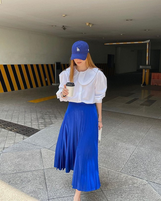 Áo blouse trắng + chân váy xanh biển đủ nổi bật và trẻ trung, nhưng vẫn đem đến sự thanh lịch, tạo sự chỉn chu, gọn gàng.