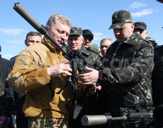 Ông Olexander Turchynov (bên phải), Chủ tịch Quốc hội kiêm Tổng thống lâm thời, đang chăm chú lắng nghe hướng dẫn từ một người huấn luyện.