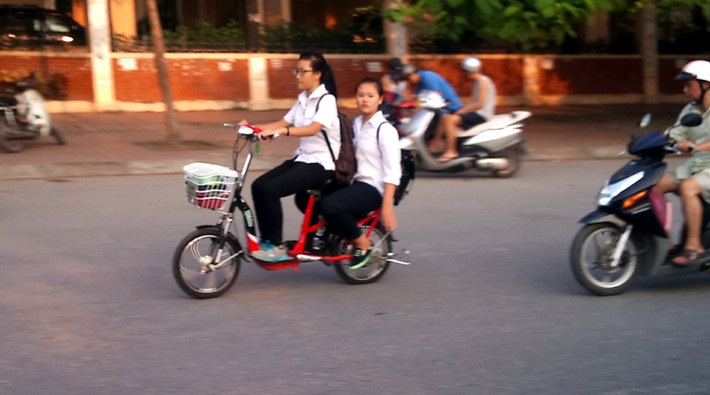 Trong thành phố, xe đạp điện không được đi quá tốc độ 30 km/h, nhưng nhiều học sinh vẫn chạy với tốc độ 40-50 km/h. Trong ảnh, học sinh đi xe đạp điện vượt qua xe tay ga.