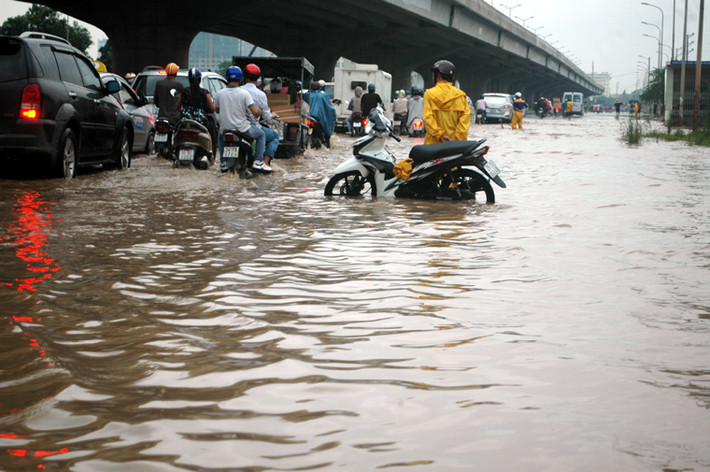 Các công nhân thoát nước làm hoa tiêu trên con đường ngập Nguyển Xiển.