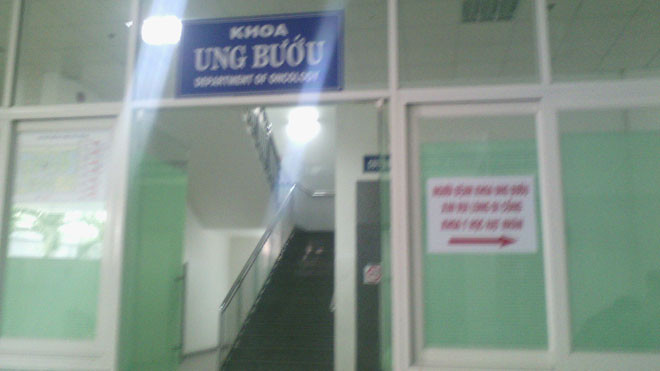 Tại tầng trệt khoa Ung bướu, nhân viên bảo vệ đã được bố trí túc trực 24/24h. Người vào ra bị hạn chế và dán bảng chỉ dẫn “Người nhà bệnh nhân khoa Ung bướu đi cổng khoa Y học hạt nhân”. Ảnh: Lao Động.
