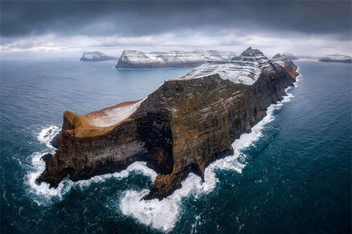 Bức ảnh chụp vách đá Kallur ở quần đảo Faroe, Đan Mạch, đã vinh dự nhận giải nhất ở hạng mục Cảnh quan biển từ trên không. Nhiếp ảnh gia Pawel Zygmunt đã chụp bức ảnh bằng máy bay không người lái ngay trước khi một trận bão ập tới.