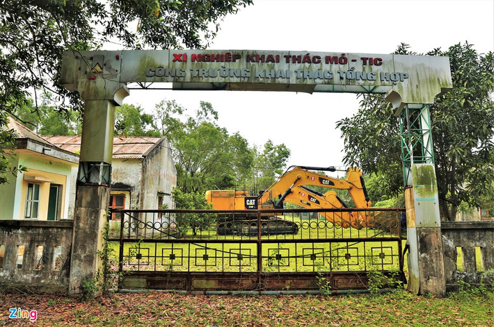 br/> Gần 10 năm bất động, đến nay dự án vẫn chưa được tái khởi động trở lại. Trong ảnh là cổng chính ra vào cửa xí nghiệp khai thác mỏ vẫn đóng kín, một số máy móc dùng khai thác dự án trước kia nay tập kết trong khuôn viên nhà điều hành, phơi mưa phơi nắng.