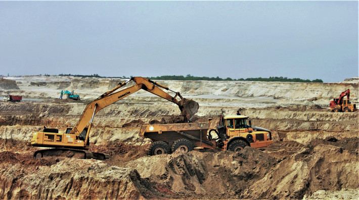 Giai đoạn 2008-2011, chủ đầu tư đã cho bóc đất tầng phủ được khoảng 12,7 triệu m3, độ sâu -34 m so với mực nước biển, thu hồi khoảng 3.000 tấn quặng. Tuy nhiên, đến tháng 11/2011, Chính phủ phải cho tạm dừng dự án để thẩm định lại thiết kế kỹ thuật và tái cơ cấu cổ đông do vướng mắc về huy động và góp vốn, dẫn đến hệ lụy như: Chậm tiến độ giải phóng mặt bằng, thiếu tiền thanh toán cho nhà thầu tư vấn lập thiết kế kỹ thuật và xây dựng khu tái định cư.
