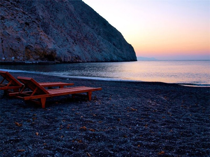 Perissa, Santorini, Hy Lạp. Bãi cát đen của biển Perissa tạo nên một khung cảnh bí ẩn nhưng vẫn tuyệt đẹp. Từ bãi biển bạn có thể đi bộ tới thành phố cổ xưa Thira từng là thuộc địa của người Sparta hoặc leo lên đỉnh núi MesaVounocủa Perissa.