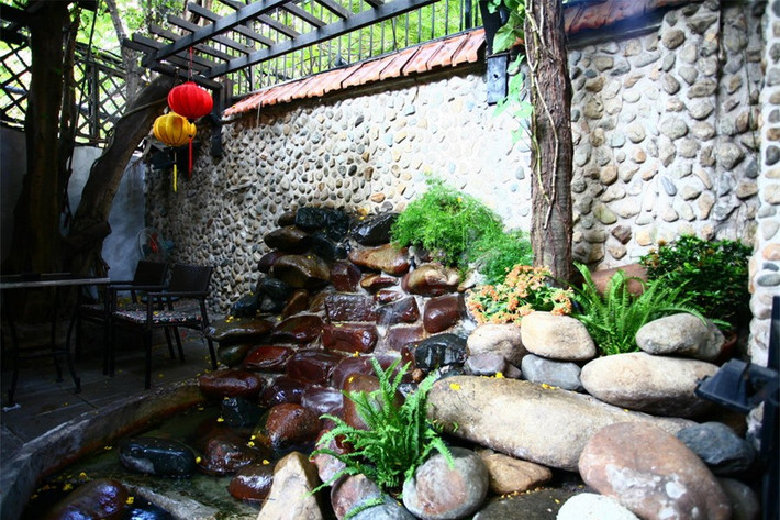 Nằm trên một con phố khá yên tĩnh của quận 1, TP Hồ Chí Minh; café “Thềm xưa” là một khoảng lặng trong lòng phố. Không gian ở đây thoáng đãng và yên bình. Đó là sự kết hợp hài hoà giữa kiến trúc và những khoảng xanh nho nhỏ của sân vườn. Ảnh: Một góc sân vườn với các vật liệu sỏi đá tự nhiên.
