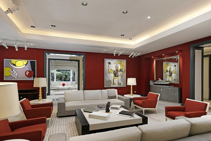 Phòng khách gây ấn tượng với gam màu đỏ thẫm bắt mắt, bộ sofa cỡ lớn, và những tác phẩm nghệ thuật độc đáo.