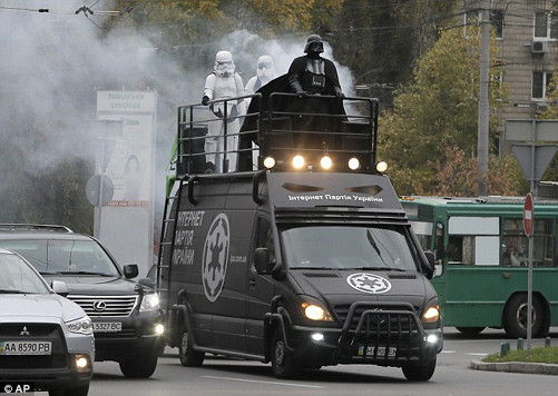 Xe tải màu đen chở Darth Vader đi lại trên các con đường đông đúc xe cộ.