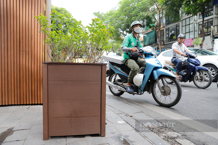 Việc bốt điện và bồn hoa "mặc áo giáp" nhựa giả gỗ thu hút sự chú ý của người đi đường.